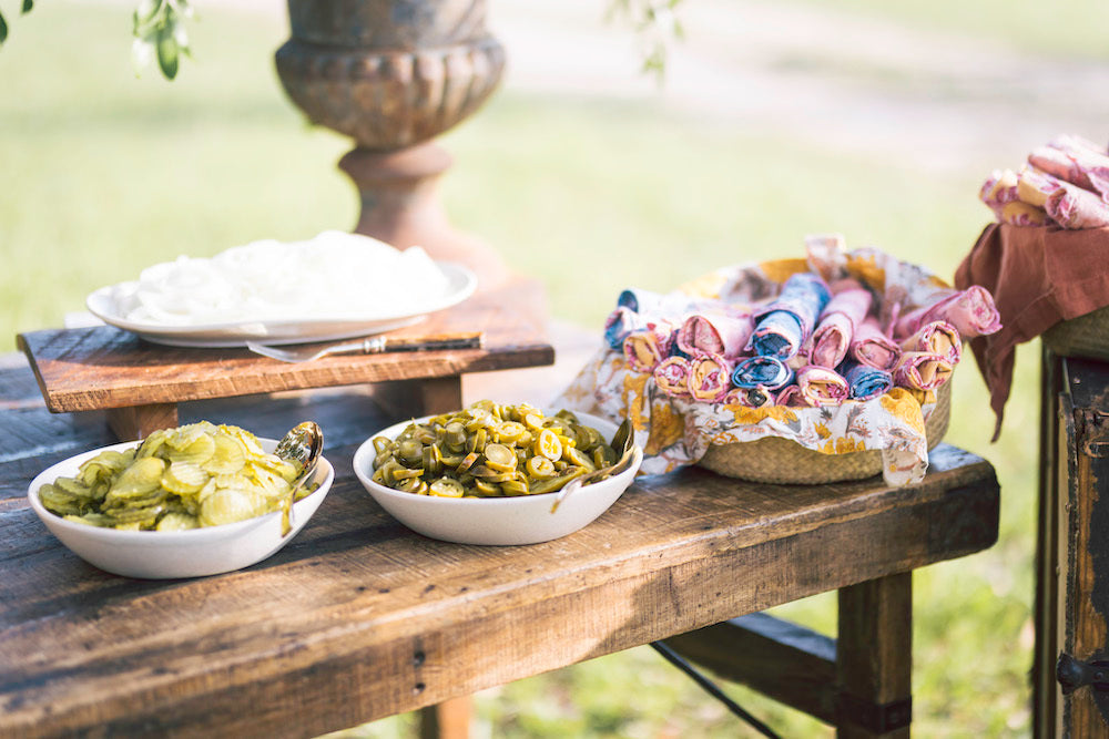 Goode Co. Catering Spread with Pickles and Jalapenos on Wooden Table Outside