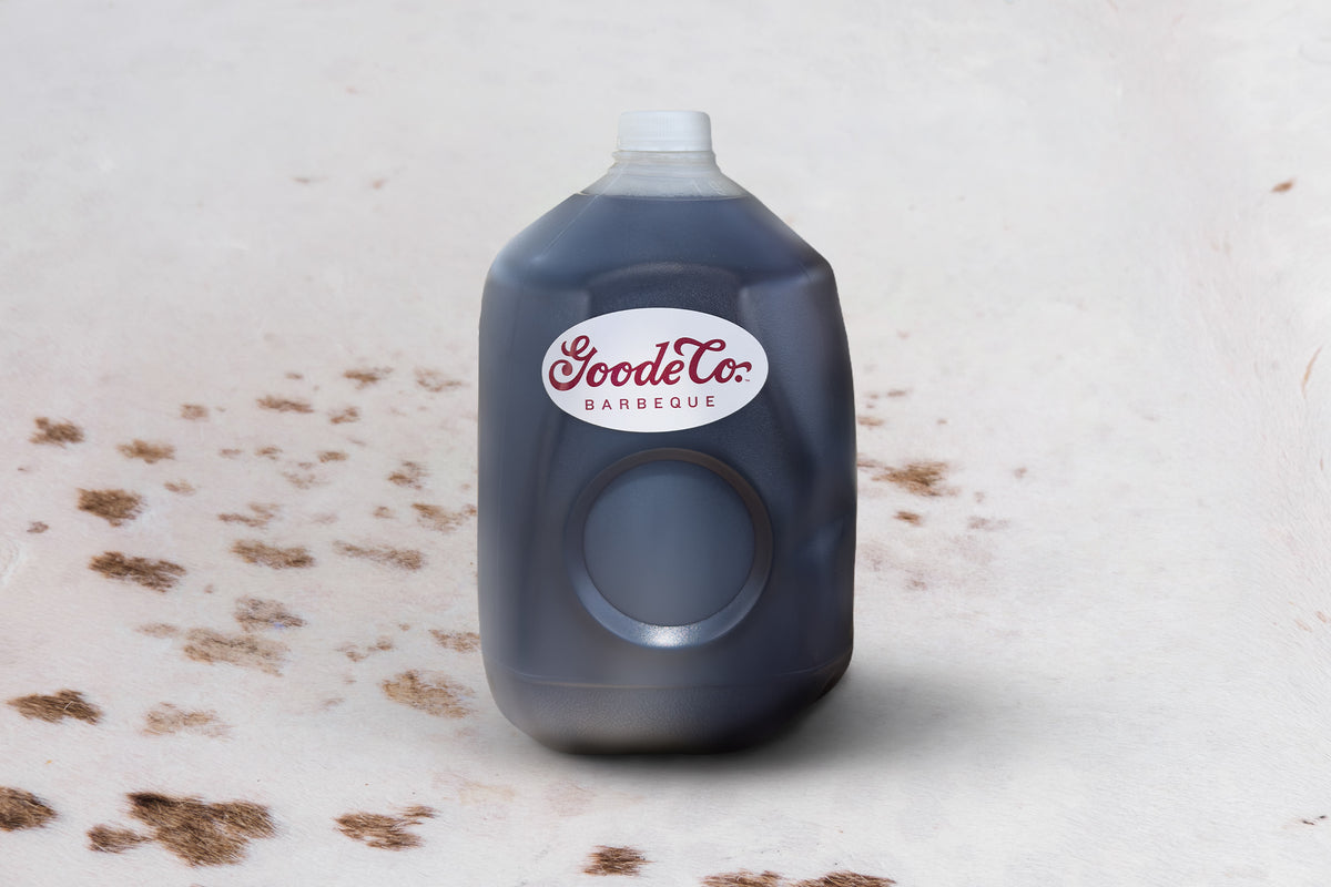 A large plastic jug of Goode Co. Barbeque iced tea on a cow hide table
