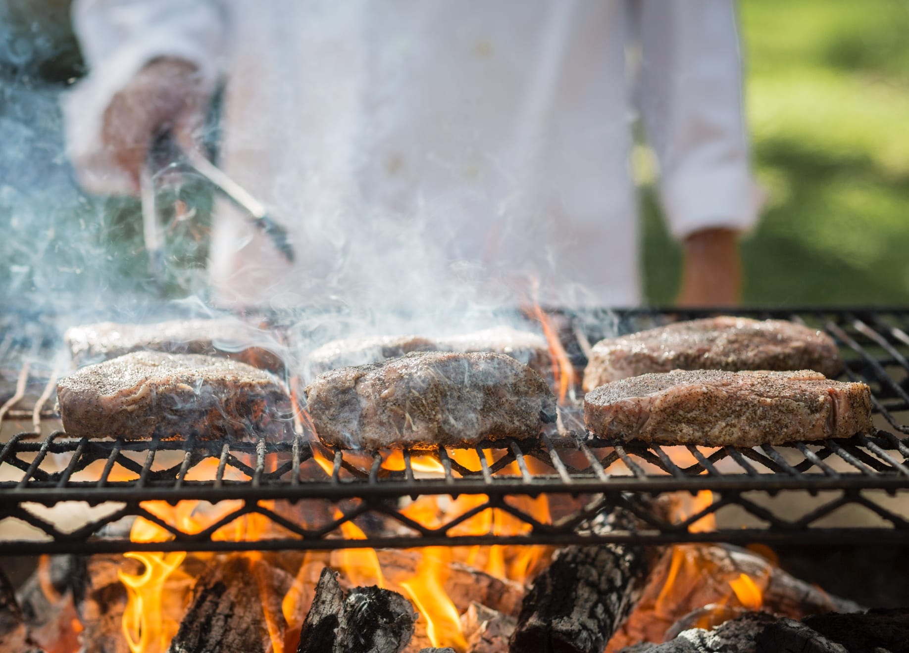 Chef Preparing Meats Over Grill at Goode Co Catering Event