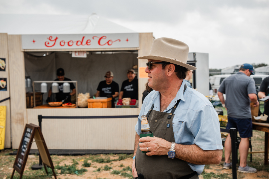 Man Wearing Sunglasses and a Cowboy Hat Standing in Front of a Goode Co. Catering Cart