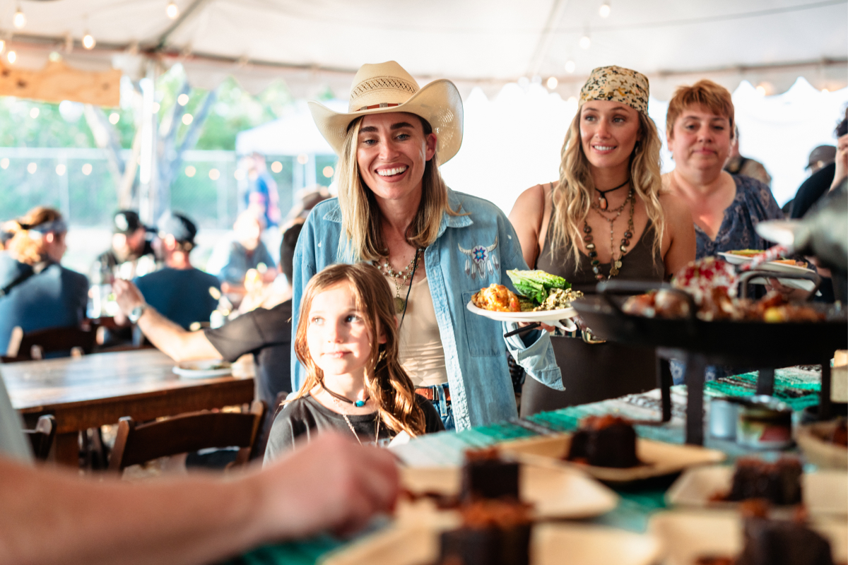 Women and a Young Girl on the Line to Be Served with Food at an Event