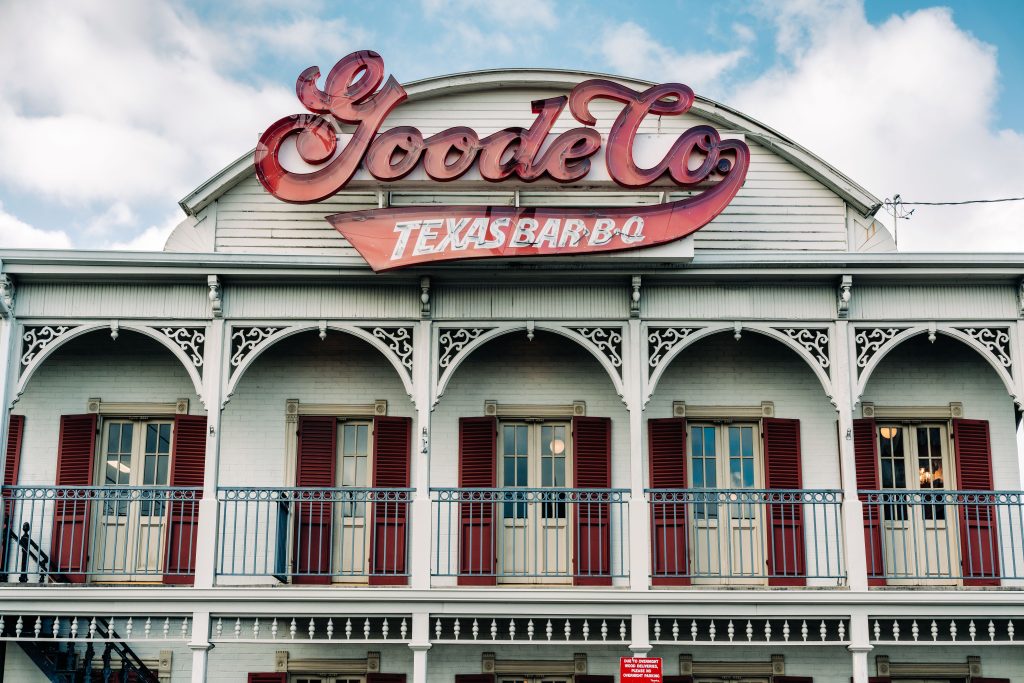 Exterior picture of Goode Co. restaurant sign and second-floor balcony.
